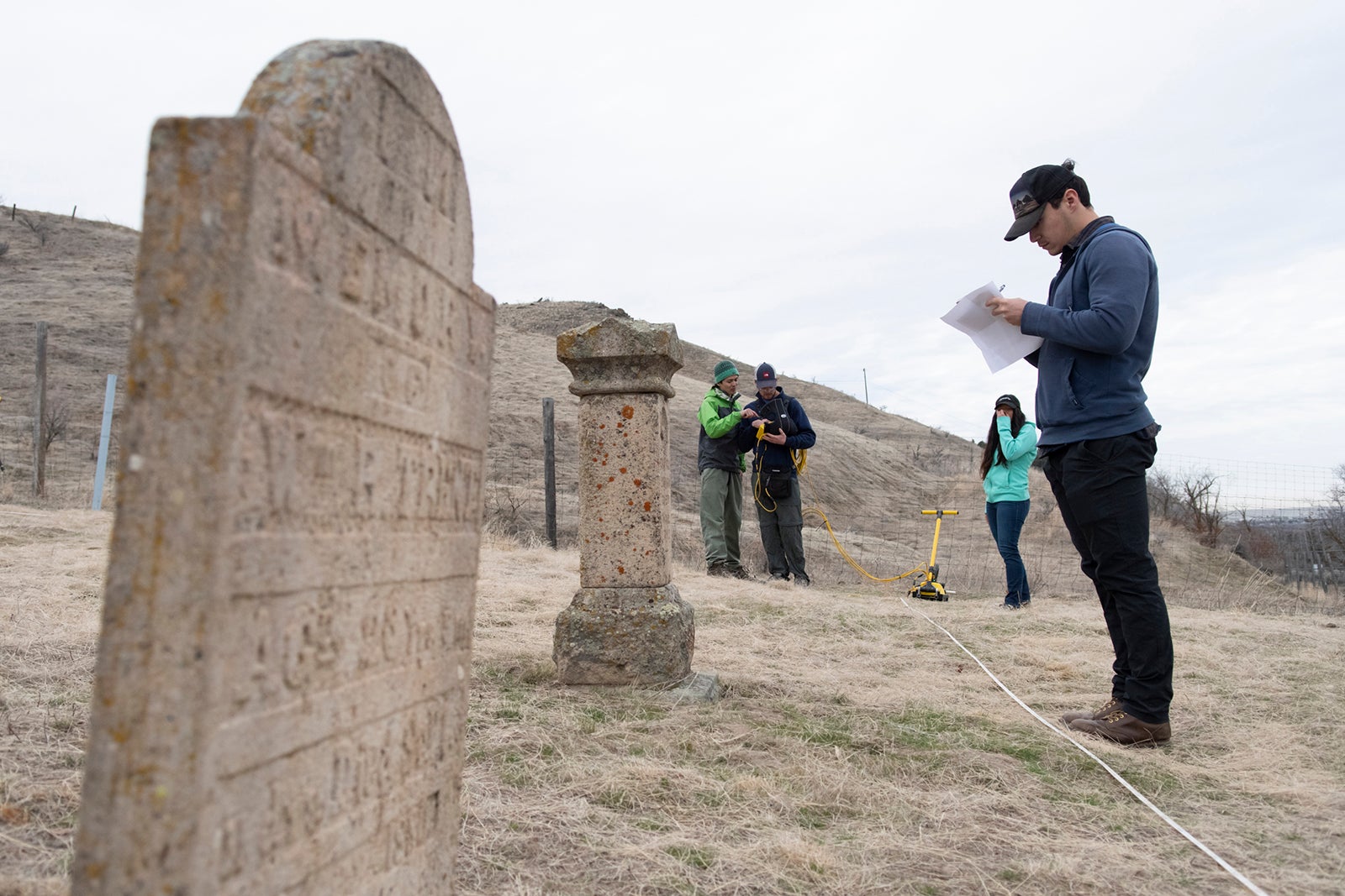 A tombstone and geophysics students conducting research