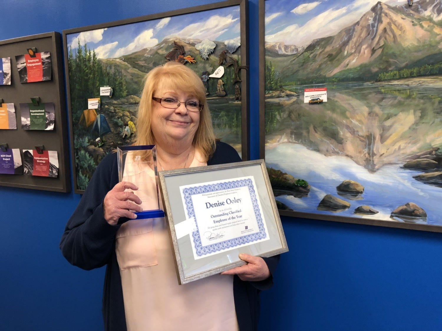 Denise stands with her award