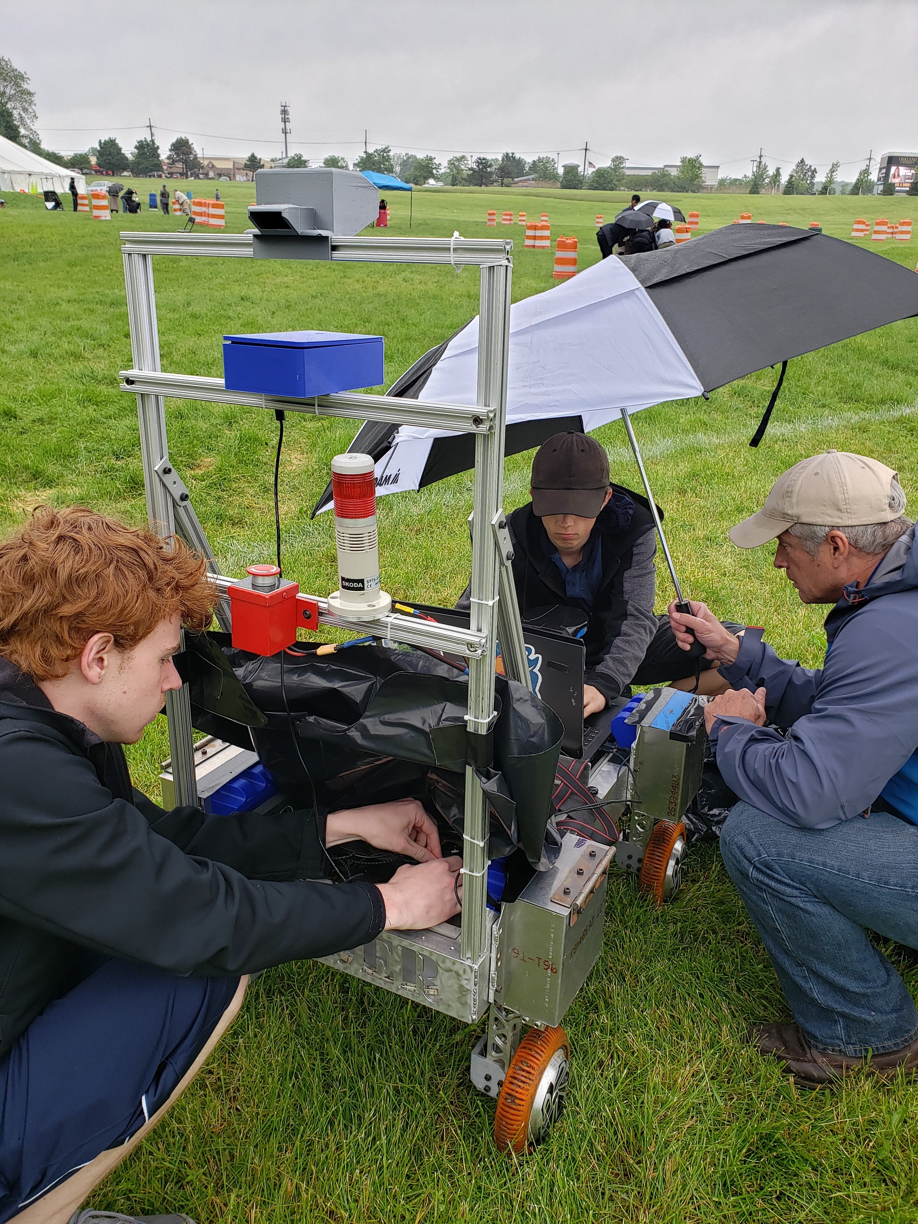 Students work on Bender in the rain with mentor Steve Swanson