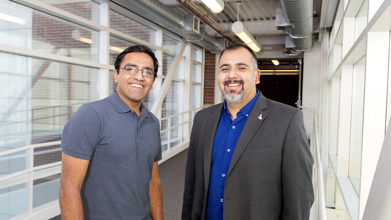 Harish and Dave stand in hallway