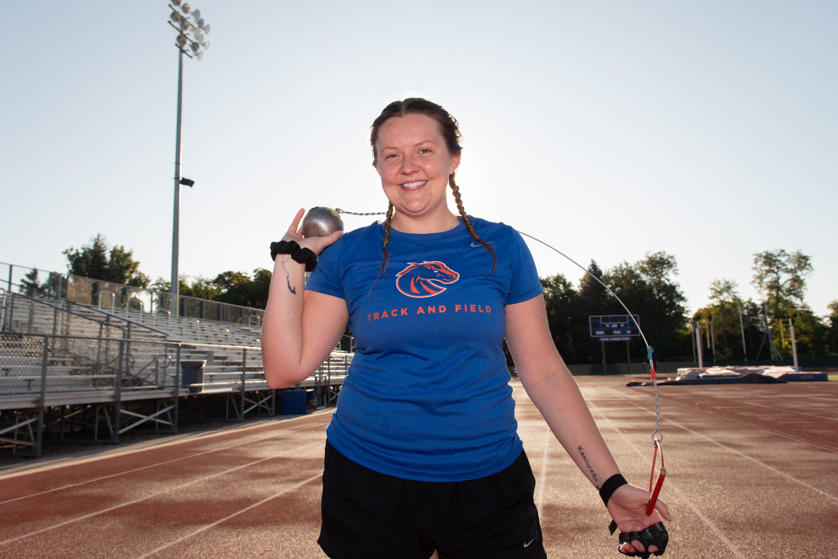 Kendra standing at track with hammerthrow