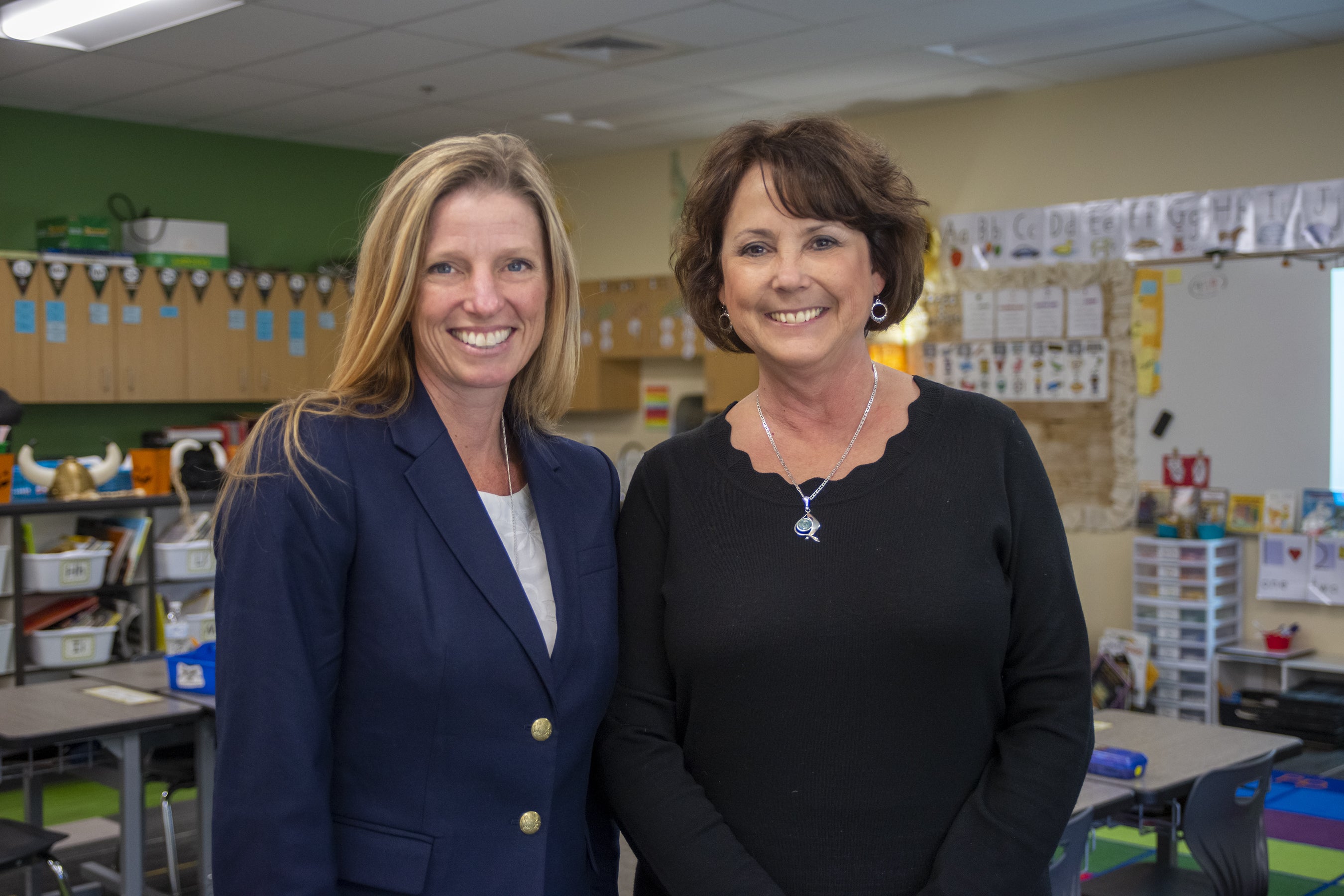 Two researchers pose in a children's classroom