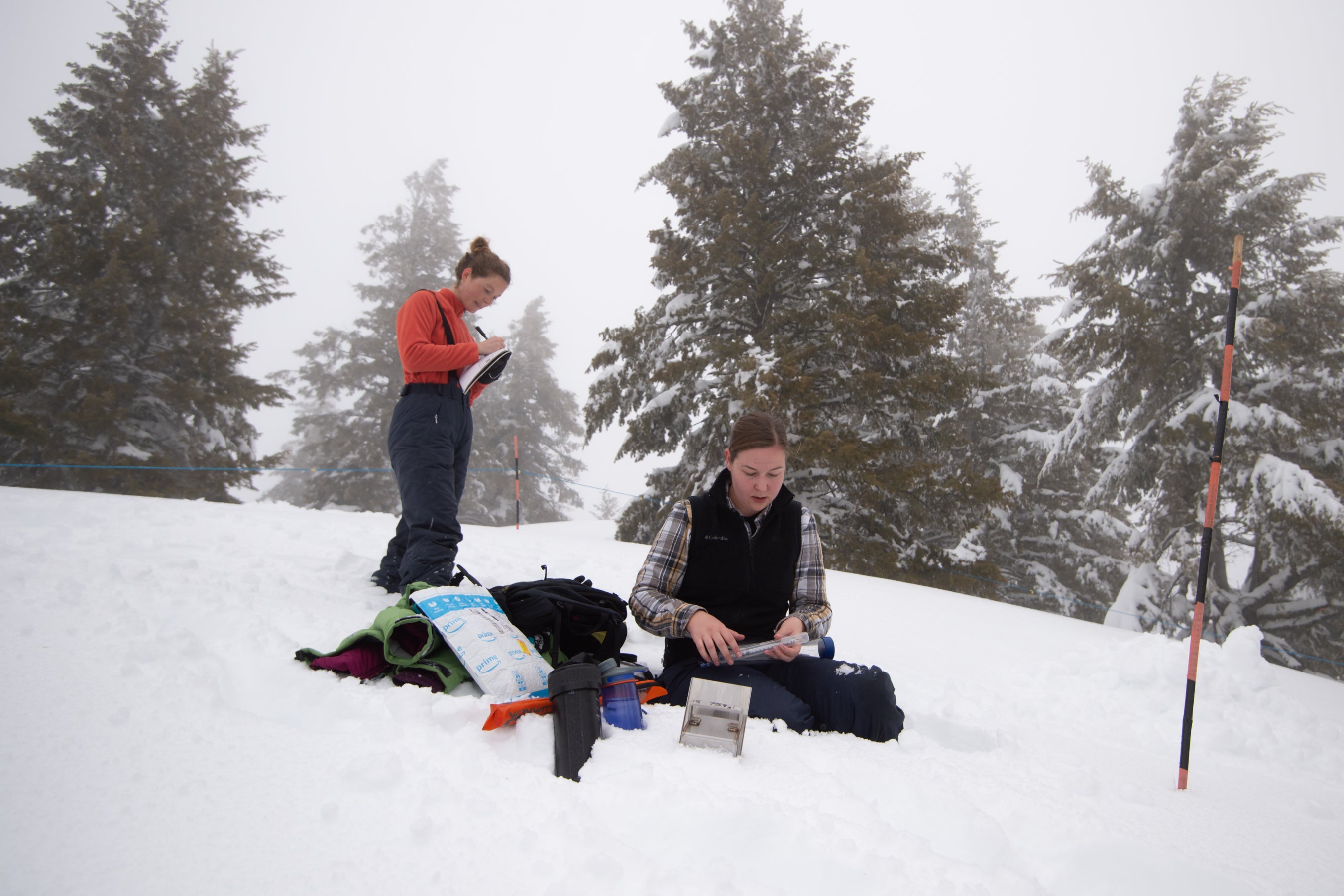 Two student conduct research on snowy mountain