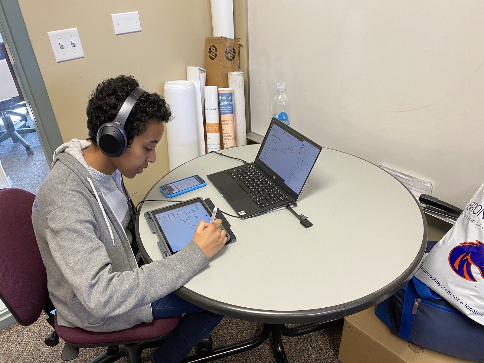 Nardos working at a table with a tablet and laptop