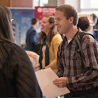student talking to an employer at a career expo