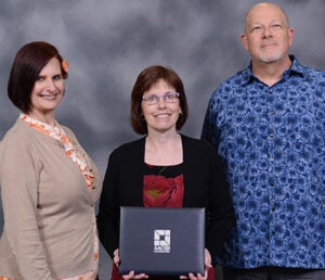 diane schooley-pettis poses with AACSB certificate of accreditation