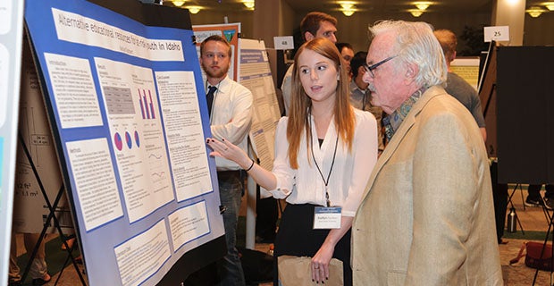 A student explains her poster at the 2015 ICUR.