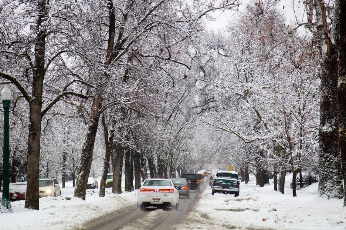 Cars driving through a snow covered street