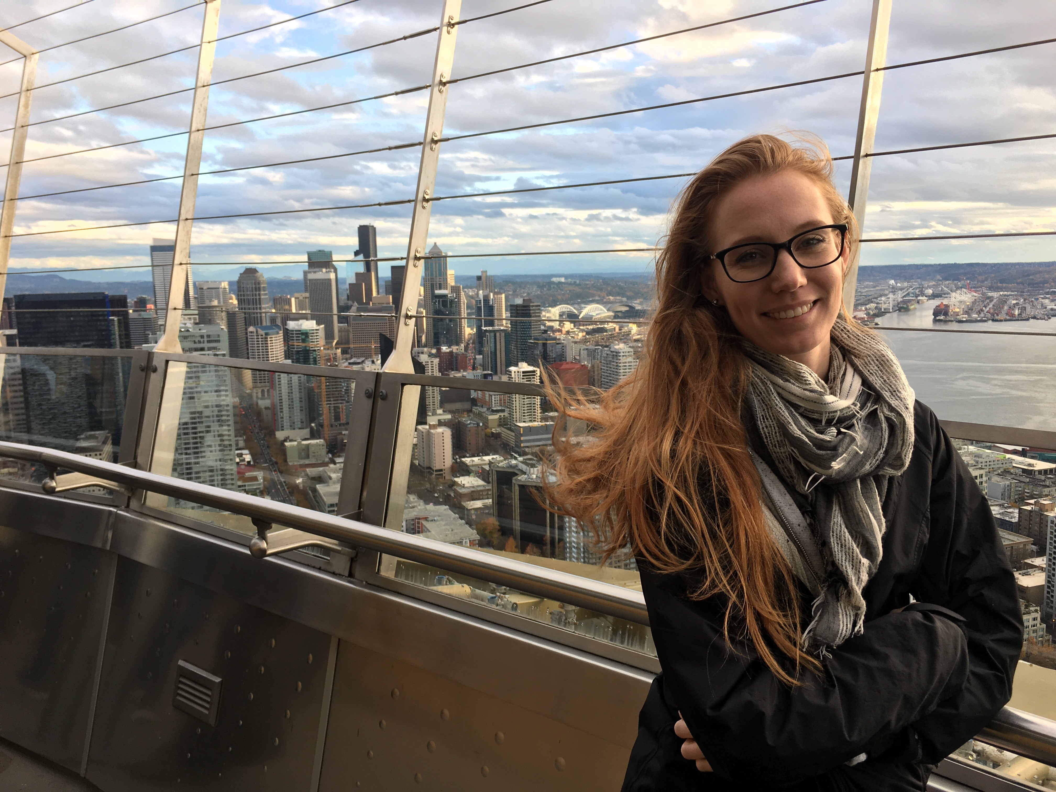 The author stands with a city skyline in the background. 