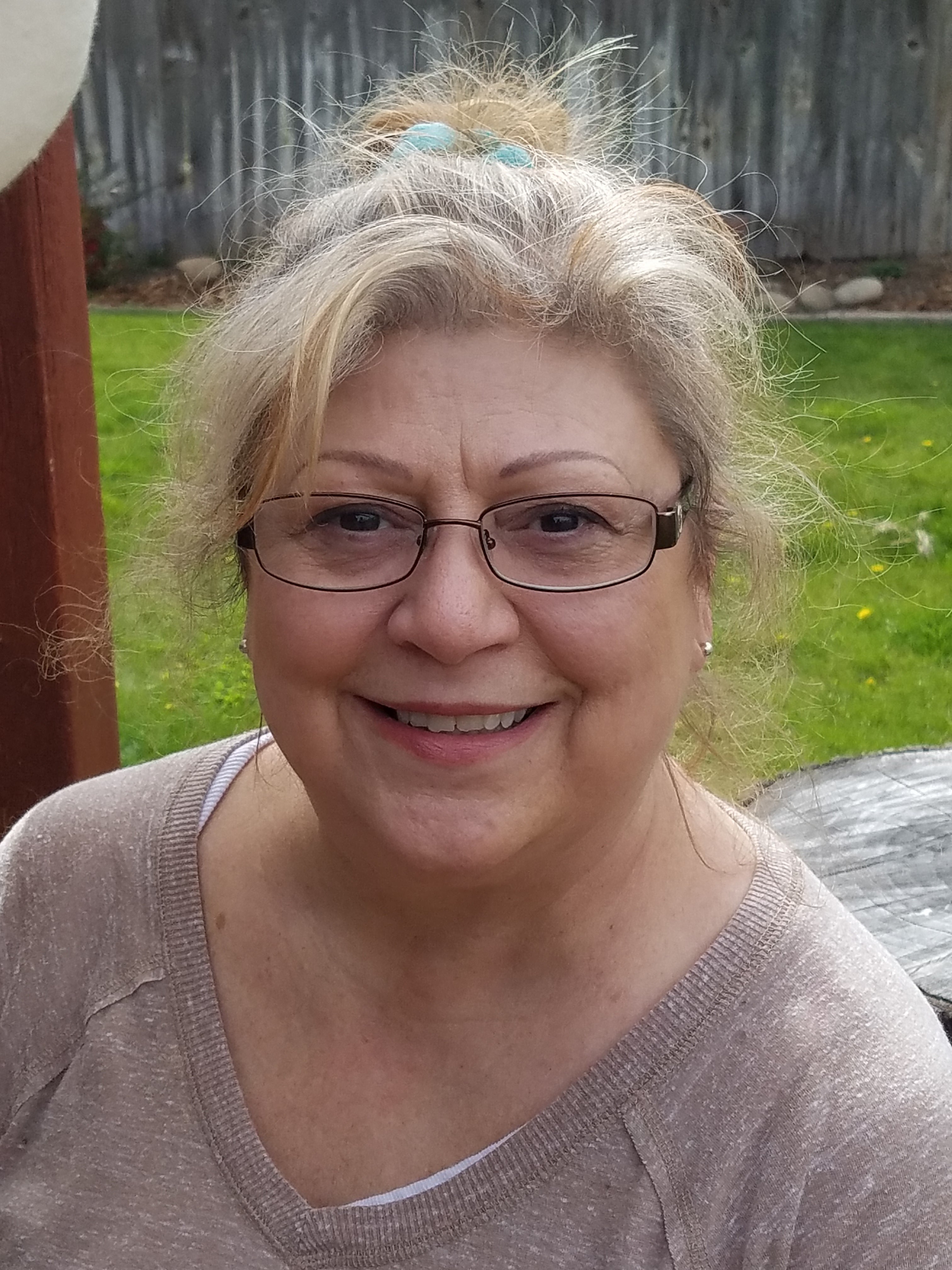 The author stands in a sunny back yard.