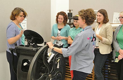 Faculty showing students how to use equipment