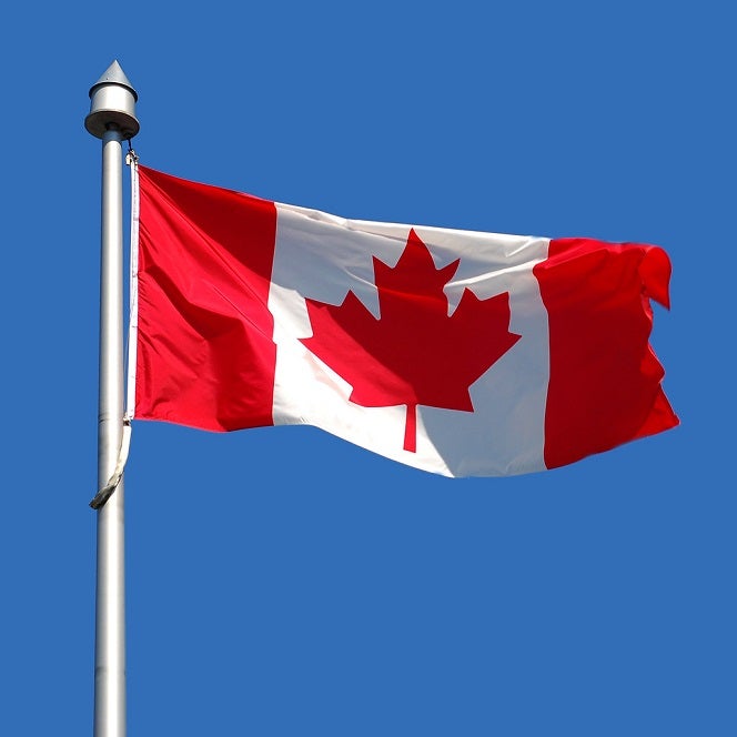 Canadian Flag flying in a bue clear sky