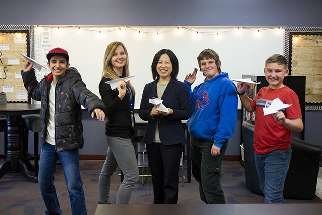 Photo of teachers with students holding paper airplanes