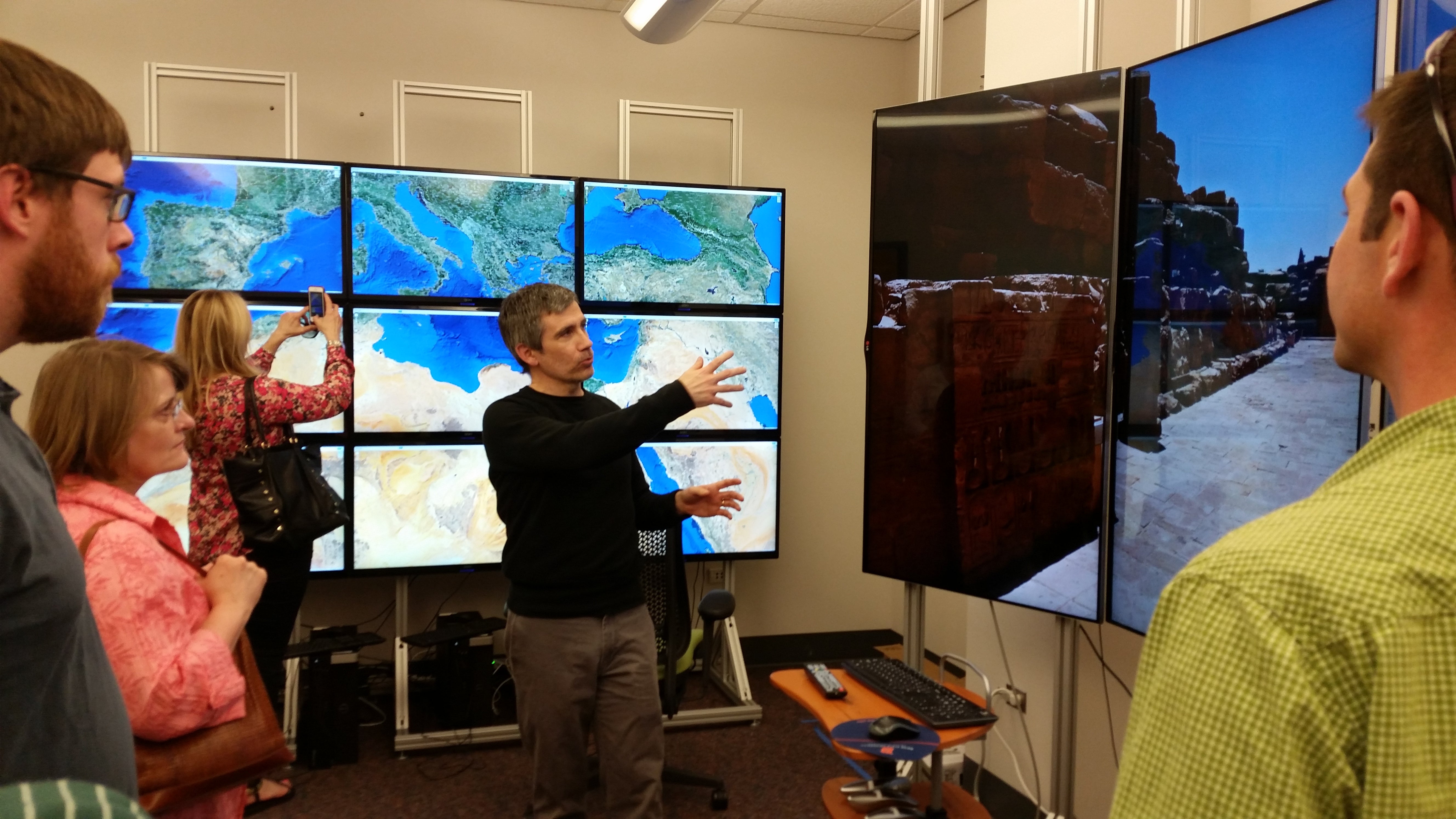 computer science teacher and audience looking at big screen monitors