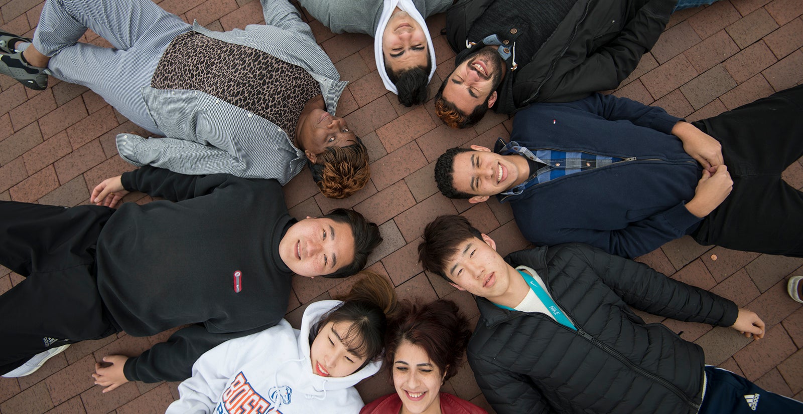 college students lying on the ground in a circle