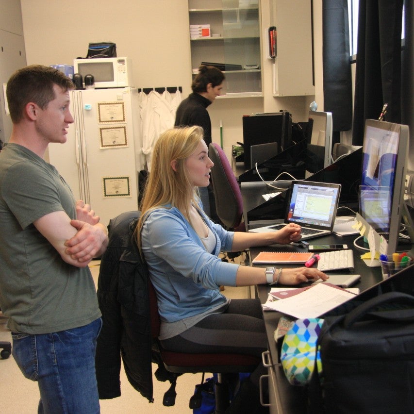 Students in a research lab reviewing data on a computer