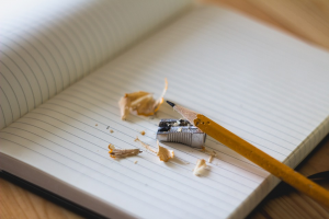 Image of a pencil and pencil sharpener on top of a notebook