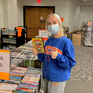CEC student helping with the public Library's book sale.