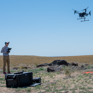 Drone pilot ready to land a drone in the sagebrush.